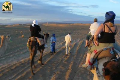 Camel caravan at sunset in Merzouga Desert – highlight of Morocco two week itinerary